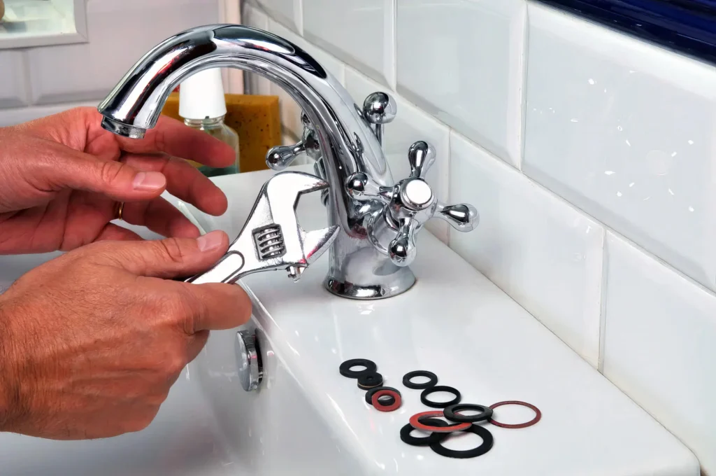 Plumber performing maintenance on a bathroom faucet in Kennesaw