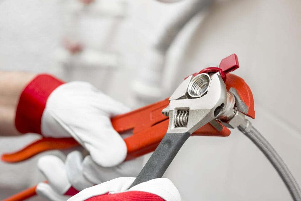 Plumber holding pipe wrenches for an emergency repair in Kennesaw