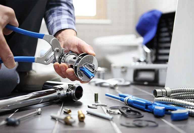 Technician repairing a plumbing fixture with professional tools in Kennesaw