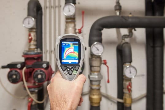 Plumber using a thermal imaging camera to inspect pipes in Kennesaw