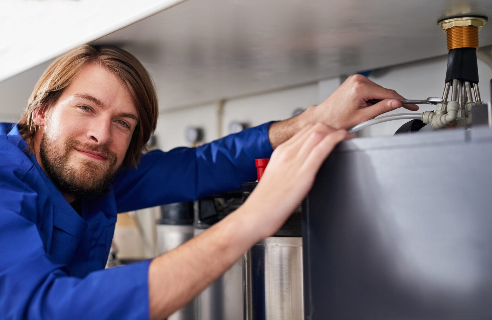 Technician servicing a residential water heater tank in Kennesaw