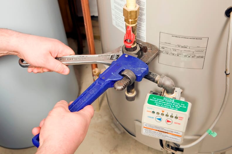 Plumber repairing a water heater valve in Kennesaw